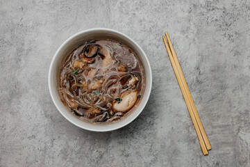 Udon soup with shrimps on a gray background. View from above.
