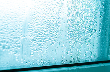 Large drops of condensate on a metal-plastic window.