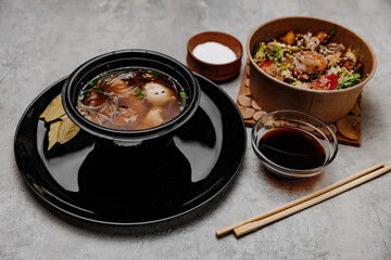 Shrimp udon soup, seafood salad and soy sauce bowl on gray background.