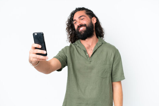 Young man with beard over isolated white background making a selfie