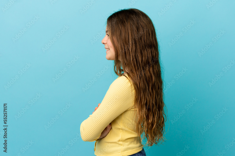 Poster Little caucasian girl isolated on blue background in lateral position