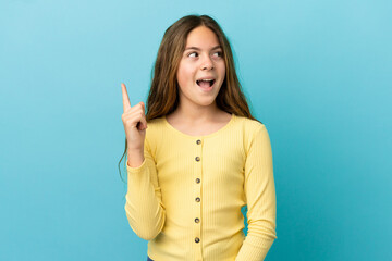 Little caucasian girl isolated on blue background intending to realizes the solution while lifting a finger up