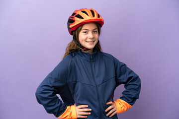 Little caucasian girl isolated on purple background posing with arms at hip and smiling