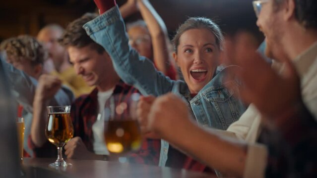 Excited Beautiful Female Sitting at a Bar Stand with Group of Friends, Cheering for a Soccer Team Playing in Tournament. Supportive Fans Applauding, Raising and Shouting in a Sports Pub.