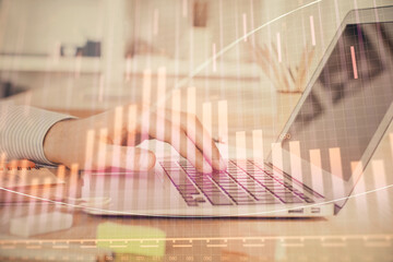 Double exposure of stock market graph with man working on laptop on background. Concept of financial analysis.