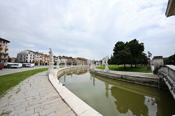View of canal with statues on square Prato della Valle and Basilica Santa Giustina in Padova, Veneto, Italy.