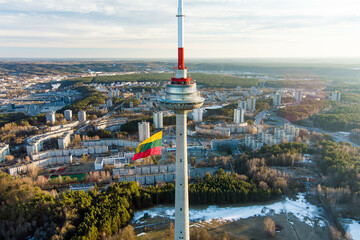 Fototapeta premium Giant tricolor Lithuanian flag waving on Vilnius television tower on the celebration of Restoration of the State Day.