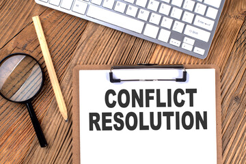 CONFLICT RESOLUTION text on paper clipboard with magnifier and keyboard on wooden background