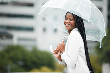 Fashion, umbrella and city with a walking black woman in the street during a cold rain or wet winter day. Water, portrait and insurance cover for young female for a walk in an urban town or New York © Mia B/peopleimages.com