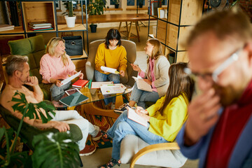 Creative brainstorming. Group of employees, men and women, having meeting, discussion at the office, indoors. Concept of business, conference