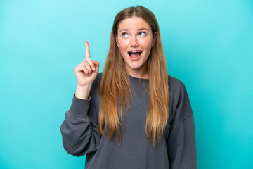 Young caucasian woman isolated on blue background intending to realizes the solution while lifting a finger up