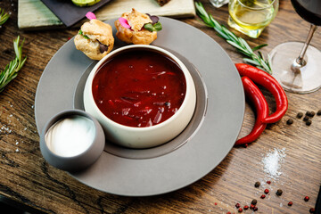 Beetroot soup Borscht with meat and sourcream in a bowl. Delicious healthy Ukrainian traditional food closeup served for lunch on a table in modern gourmet cuisine restaurant