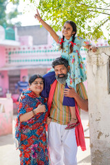 Fototapeta na wymiar Happy indian farmer couple with his little girl