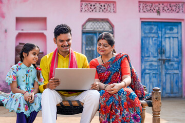 Indian rural family using laptop at home.