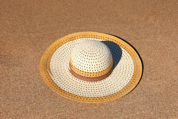 Fototapeta na wymiar Beautiful straw hat on sand outdoors. Beach accessory
