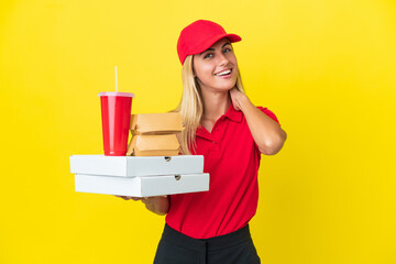 Delivery Uruguayan woman holding fast food isolated on yellow background laughing