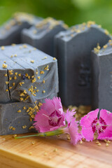  Dark blue handmade soap with pink flowers on a green background