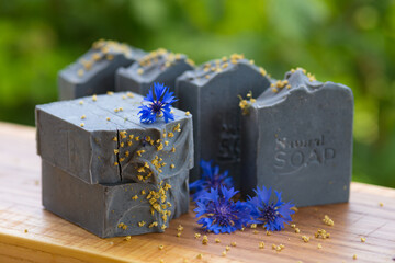  Dark blue handmade soap with blue flowers on a green background