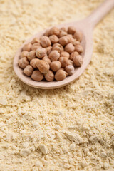 Spoon with seeds on chickpea flour, closeup