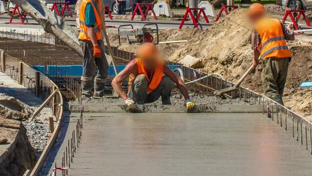 Concrete leveling works for road construction with many workers in uniform, excavators and mixer machine timelapse. Reconstruction of tram tracks