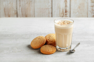 coffee raff in a glass close-up with homemade cookies. coffee with milk and grated nut on light...