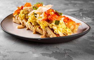 baked brioche, scrambled eggs, and crab meat on plate