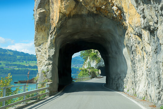 curvy road along lake Thunersee, with tunnels. Swiss landscape Bernese Oberland.
