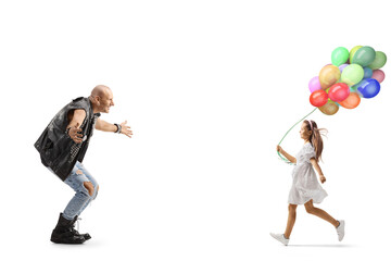 Full length profile shot of a girl with balloons running towards a punk