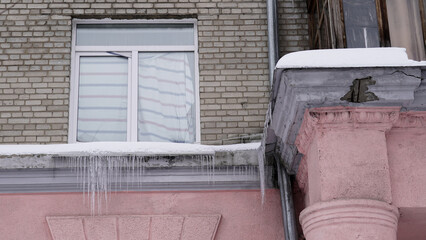 Frozen icicles on the roofs and facades of houses