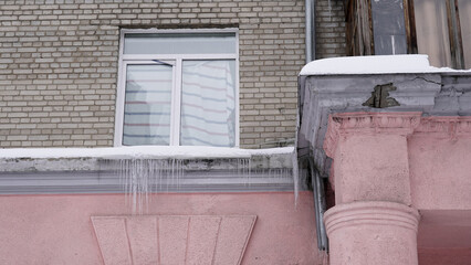 Obraz na płótnie Canvas Frozen icicles on the roofs and facades of houses