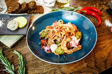 Warm salad with Argentinian king prawns. Almond potato, mini romaine lettuce, carrot, cherry tomato, pesto, black root chips, caramelized walnut, beet balsamic. Food served in modern restaurant