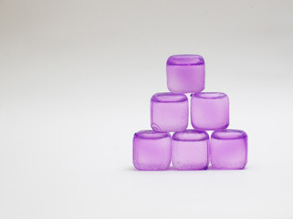 purple fake ice cubes on white background except copy space
