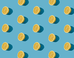 Summer pattern made with fresh yellow lemon slice on bright light blue background. Minimal background summer concept on bright sunlight. - 552596923