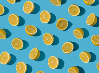 Summer pattern made with fresh yellow lemon slice on bright light blue background. Minimal background summer concept on bright sunlight with sharp shadows - 552596986
