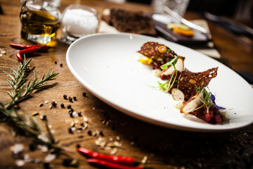 Steak tartare: Horseradish creme, black bread and baguette chips on a plate. Delicious healthy food closeup served for lunch on a table in modern gourmet cuisine restaurant