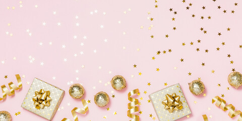 Christmas composition flat lay. Gold party decorations, confetti, gifts on pastel pink background. Christmas, winter holiday, new year concept. Top view, copy space.