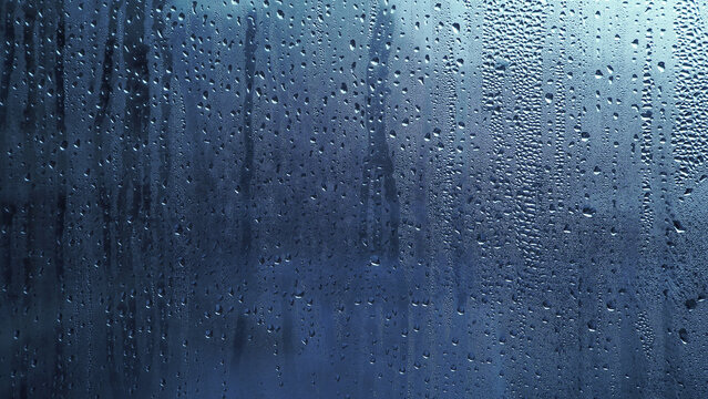 Condensation on window glass in frosty winter weather. Background in the form of small drops on the glass.