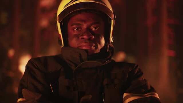 Close Up Portrait of a Black Firefighter in Professional Uniform Looking at Camera, Sweat Running Across His Face. African Fireman Posing During a Wildland Forest Fire Operation.