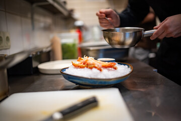 chef cooking crab legs with caviar on kitchen