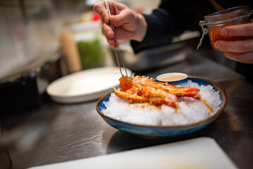 chef cooking crab legs with caviar on kitchen
