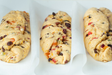 Traditional Christmas Stollen pie is ready for baking in the oven. Making German Christmas bread with raisins and candied fruits . White background. Template for a Christmas pastry recipe