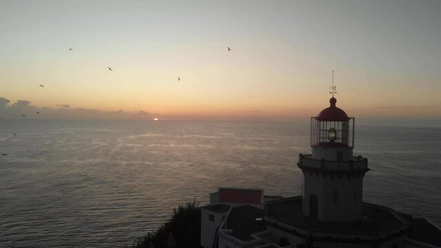 Epic sunrise, drone shot of Lighthouse Farol Ponta do Arnel on San Miguel Island. Aerial view of amazing landscape of Lighthouse on island in atlantic ocean, 4k footage. Azores, Atlantic Coastline