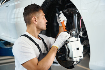 Man removing old wheel from car in tire fitting