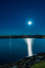 Fototapeta na wymiar Full Moon burst over a lake