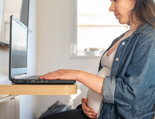 pregnant woman working on laptop from home