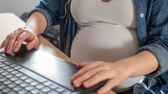pregnant woman working on laptop from home