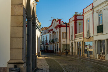 Fototapeta na wymiar Miasteczko Tavira w Portugalii. Piękne kolorowe budynki, słoneczny dzień, niebieskie niebo. 