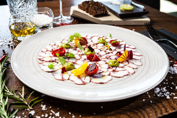 Octopus carpaccio. Spinach cream, cherry tomatoes. Delicious healthy Italian traditional food...