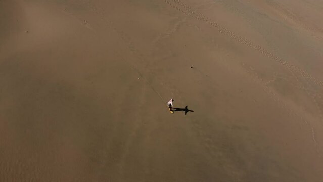 Epic sanbording. Boarding on sand. Man in white. Aerial view of Huacachina Oasis, in the desert sand dunes near the city of Ica, Peru