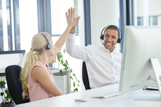 Call center, high five and crm business office employees excited about sale success and support. Customer service, b2b and web help collaboration of staff with diversity happy about sales target